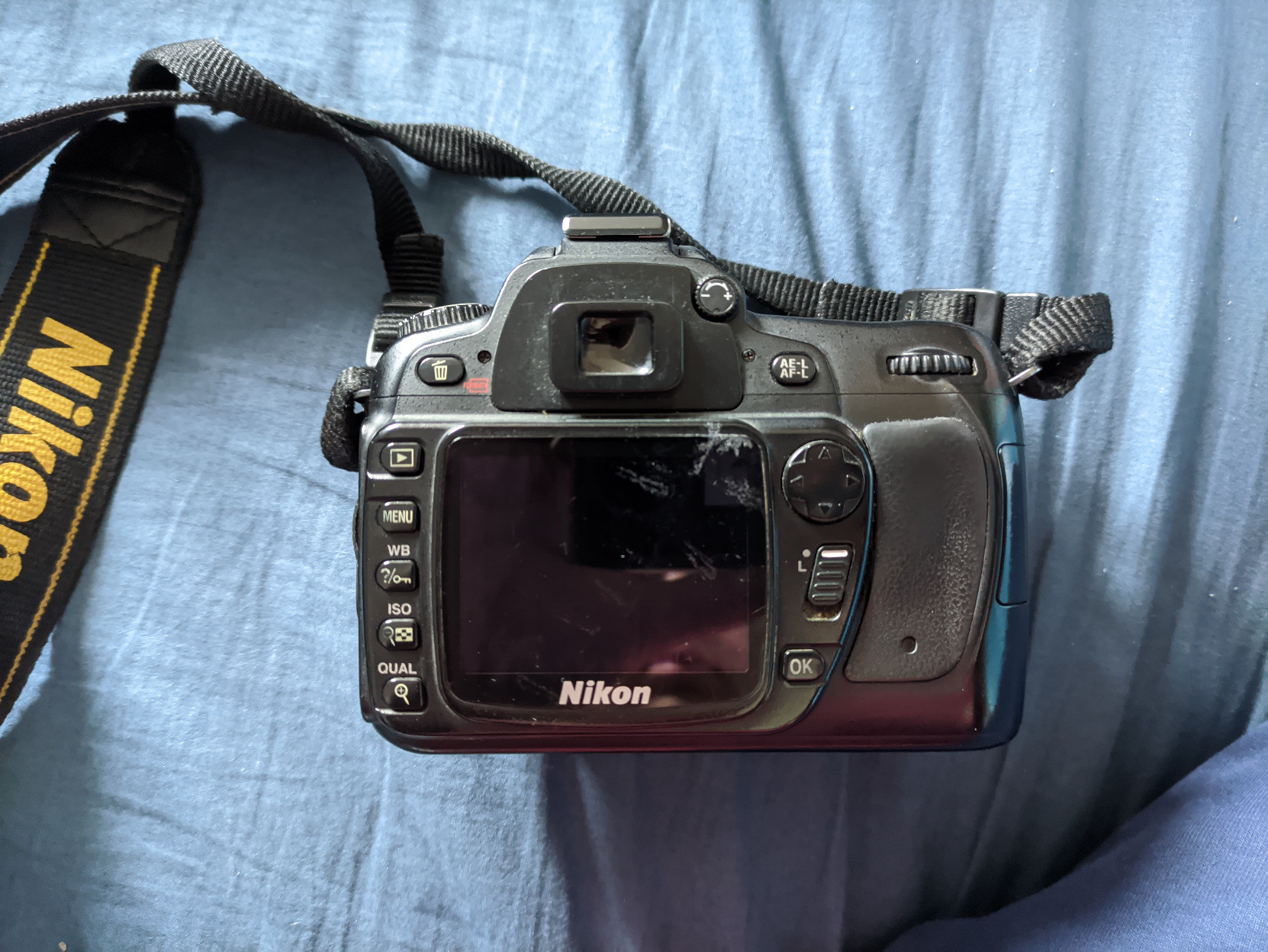 A photo of the back of the Nikon D80. The screen looks quite scratched up and/or dirty. The rubber eyepiece is taken off (because I wear glasses).