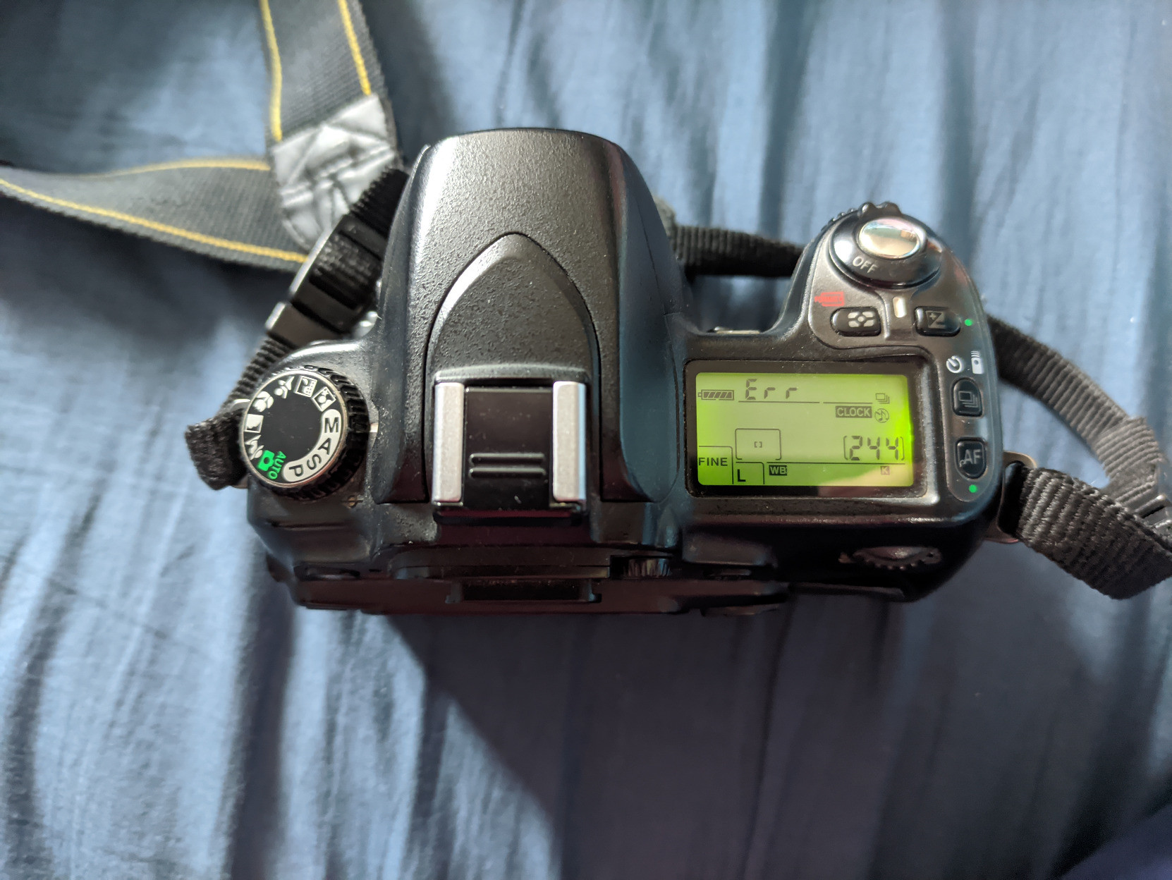 A photo of the top of the Nikon D80. The power dial is visibly worn down. The small secondary screen is showing "Err".